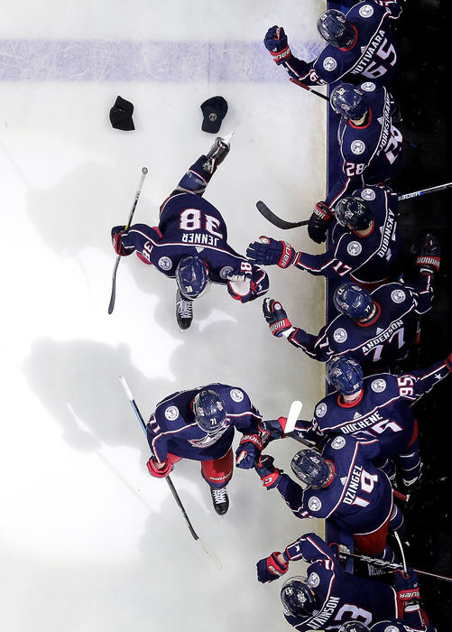 Sports Feature - 2nd placeColumbus Blue Jackets center Boone Jenner (38) gets high fives from teammates as he skates behind left wing Nick Foligno (71) after scoring his third goal of the night during the third period of their game against the Boston Bruins at Nationwide Arena in Columbus. The Blue Jackets won 7-4. (Adam Cairns / The Columbus Dispatch)